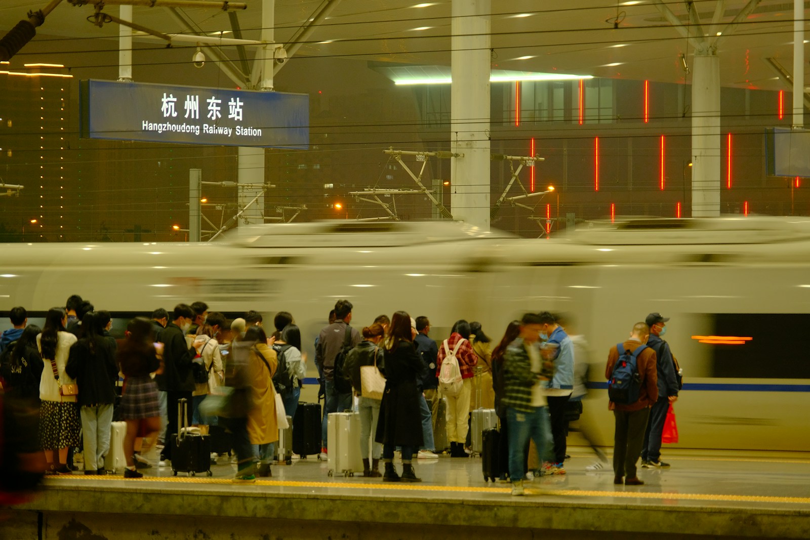 People wait for a train at a railway station.